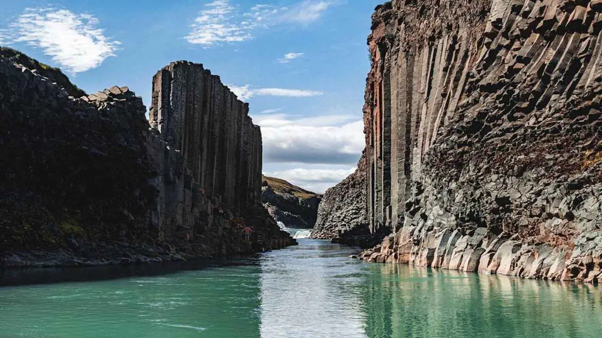Hexagonal basalt columns above the turquoise glacial river at Stuðlagil Canyon, the main stop on Seyðisfjörður tours inland through East Iceland